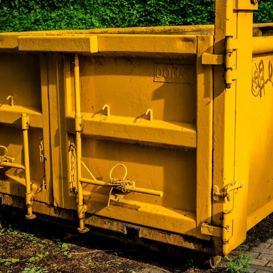 Close-up of a yellow steel skip's doors and latches